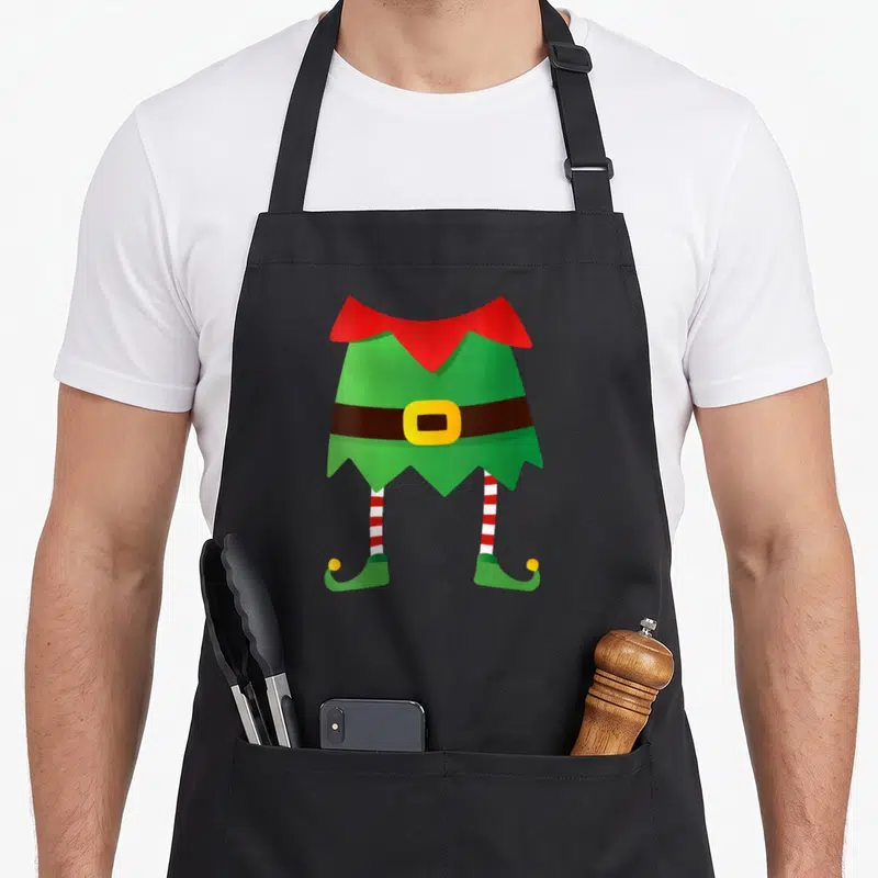 Tablier de cuisine noir avec illustration d'un costume d'elfe vert, ceinture marron et bas rayés rouges et blancs.