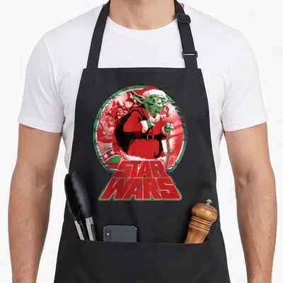Tablier de cuisine noir avec illustration vintage de Yoda en costume de Père Noël et logo Star Wars rouge.