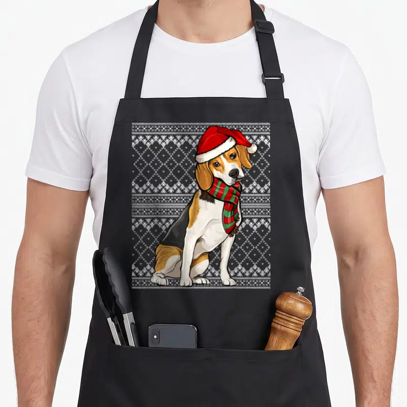Tablier de cuisine noir avec illustration d'un beagle portant un bonnet de Père Noël et une écharpe à carreaux rouges et verts.