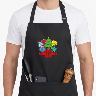 Tablier de cuisine noir avec des personnages colorés autour d'un sapin et le texte Best Christmas Ever en rouge.