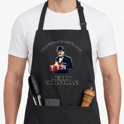 Tablier de cuisine noir avec illustration d'un homme en costume tenant un cadeau et le texte Some little grey cells for you.