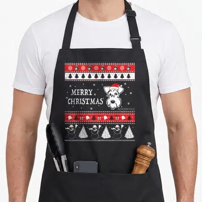 Tablier de cuisine noir avec illustration de Schnauzer en bonnet de Noël et motifs festifs rouges et blancs.