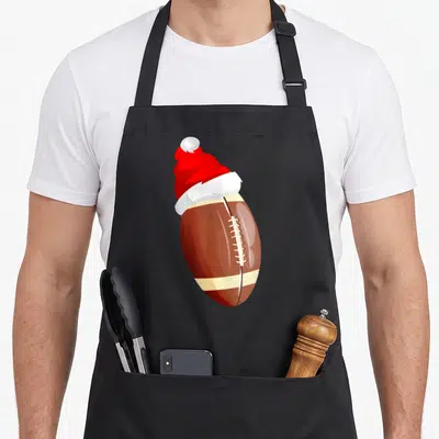 Tablier de cuisine noir avec illustration d'un ballon de rugby coiffé d'un chapeau de Père Noël rouge et blanc
