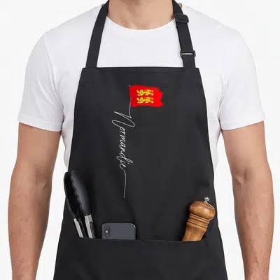 Tablier de cuisine noir avec drapeau normandie aux lions jaunes et inscription Normandie en blanc.