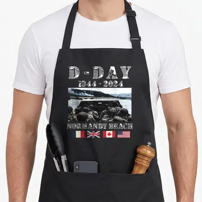 Tablier de cuisine noir avec illustration historique D-Day 1944-2024 et quatre drapeaux nationaux alignés en bas.