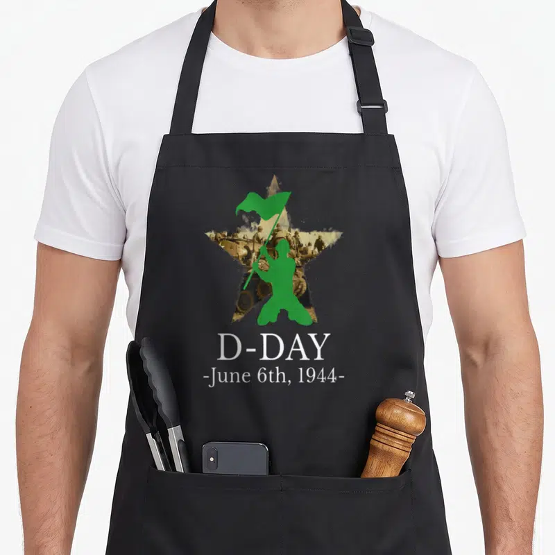 Tablier de cuisine noir avec silhouette verte d'un soldat et texte blanc D-Day juin 1944 sur fond d'étoile.