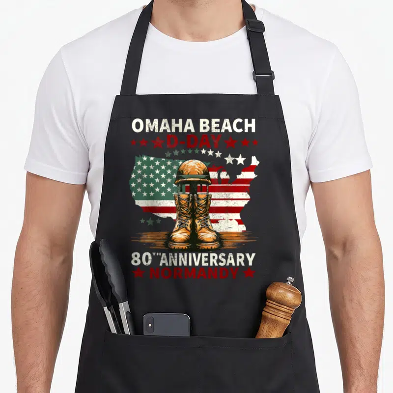 Tablier de cuisine noir avec bottes militaires, casque et drapeau américain pour le 80e anniversaire du Débarquement en Normandie.