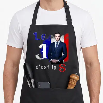 Tablier de cuisine noir avec portrait en costume et texte Le J c'est le S sur fond tricolore stylisé.
