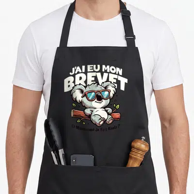 Tablier de cuisine noir avec un koala portant des lunettes de soleil sur une branche.