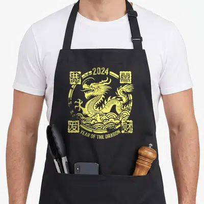Tablier de cuisine noir avec illustration jaune représentant un dragon vintage entouré de symboles chinois et de vagues stylisées.