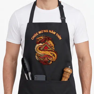 Tablier de cuisine noir avec un dragon doré enroulé autour d'une pique rouge et du texte vietnamien.