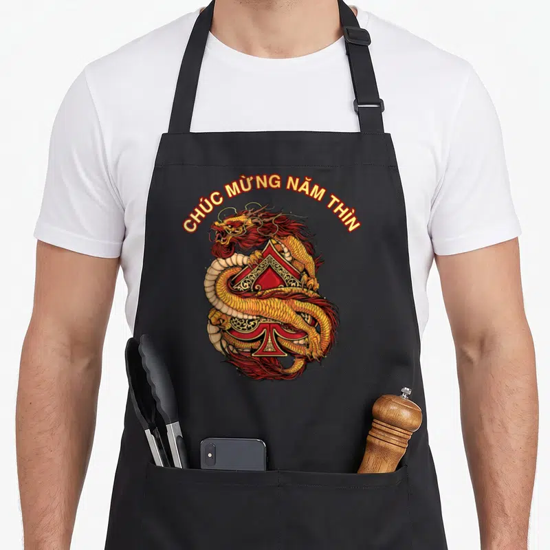 Tablier de cuisine noir avec un dragon doré enroulé autour d'une pique rouge et du texte vietnamien.