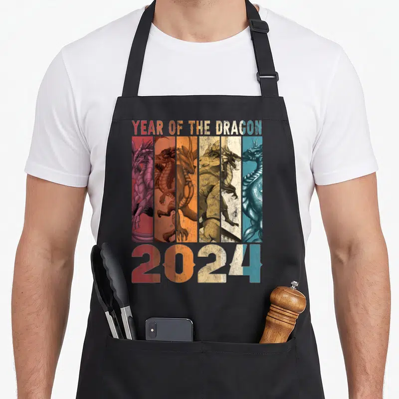 Tablier de cuisine noir avec six dragons stylisés et l'inscription Year of the Dragon 2024 en lettres dégradées.