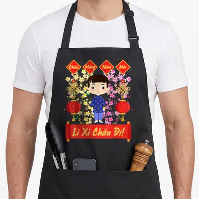 Tablier de cuisine noir avec illustration d'un enfant en tunique bleue entouré de fleurs et de lanternes rouges vietnamiennes.