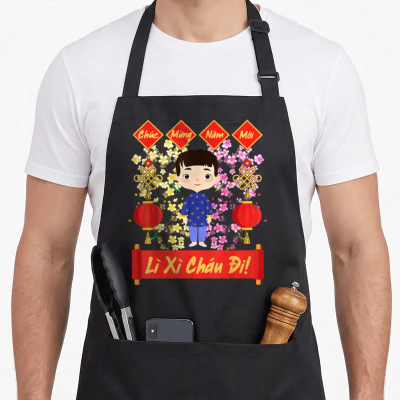 Tablier de cuisine noir avec illustration d'un enfant en tunique bleue entouré de fleurs et de lanternes rouges vietnamiennes.