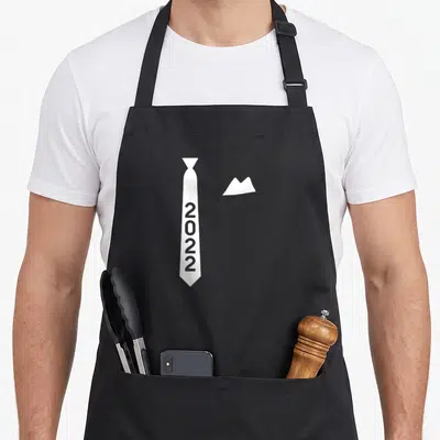 Tablier de cuisine noir avec une illustration de cravate blanche portant l'inscription 2022 et un bout de mouchoir.