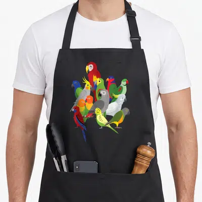 Tablier de cuisine noir avec illustration groupée d'ara, cacatoès, gris gris et perruche aux plumages vifs et variés.