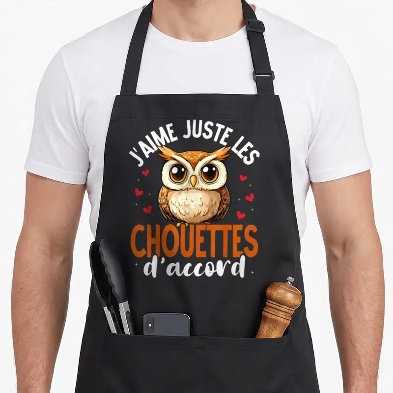 Tablier de cuisine noir avec une chouette marron et le texte J'aime Juste Les Chouettes d'accord entouré de petits cœurs rouges.