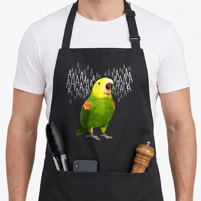 Tablier de cuisine noir avec illustration colorée d'un perroquet « amazon » criant et de multiples lettres A blanches flottantes autour de sa tête.