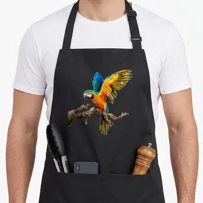 Tablier de cuisine noir avec un macou aux ailes déployées posé sur une branche sinueuse.
