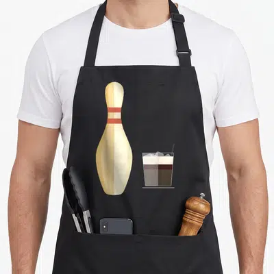 Tablier de cuisine noir avec illustration d'une planche de bowling et d'un verre à cocktail sur fond uni.