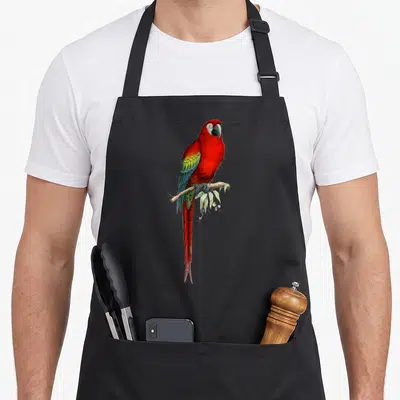 Tablier de cuisine noir avec illustration détaillée d'un perroquet arlate rouge perchés sur une branche.