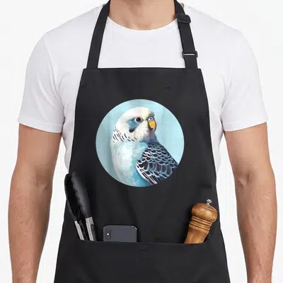 Tablier de cuisine noir avec illustration circulaire d'une perruche ondulée bleue et blanche sur fond clair.