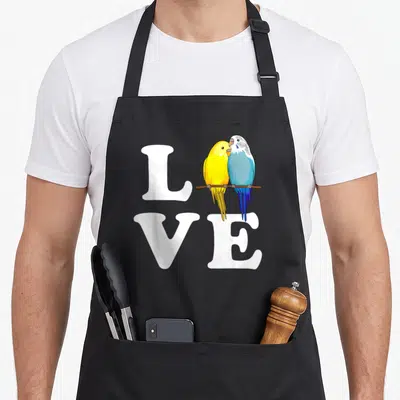 Tablier de cuisine noir avec linscription Love et deux perruches ondulées jaune et bleue sur une branche.