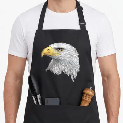 Tablier de cuisine noir avec illustration détaillée d'un pygargue à tête blanche de profil.