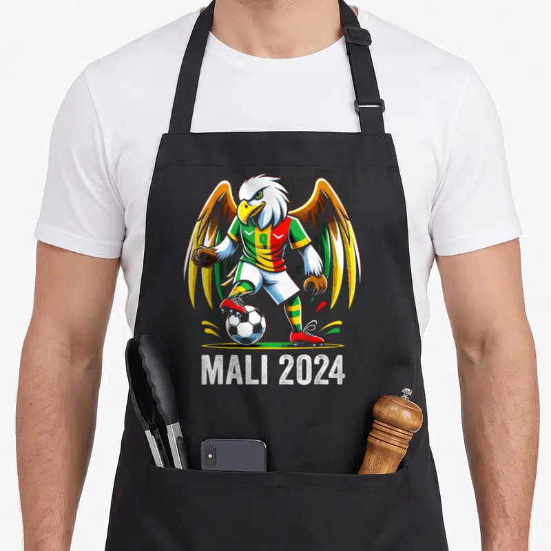 Tablier de cuisine noir avec un aigle footballeur portant un maillot Mali 2024 aux couleurs vives.