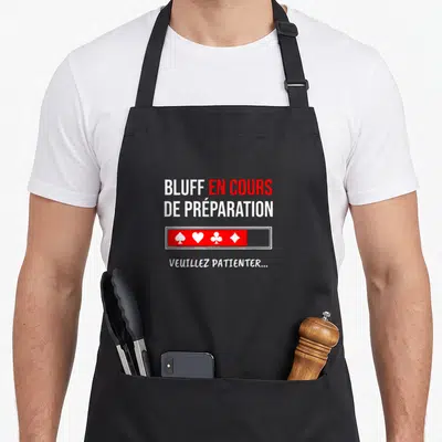 Tablier de cuisine noir avec texte bluff en cours de préparation et icônes de cartes rouges et blanches.