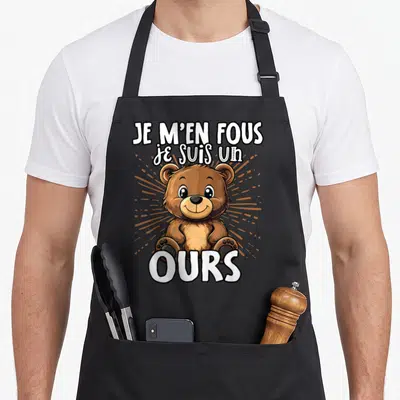 Tablier de cuisine noir avec un ours marron souriant et le texte Je m'en fous je suis un ours.
