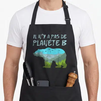 Tablier de cuisine noir avec silhouette d'ours intégrant montagnes forêts et texte « nature environnement »
