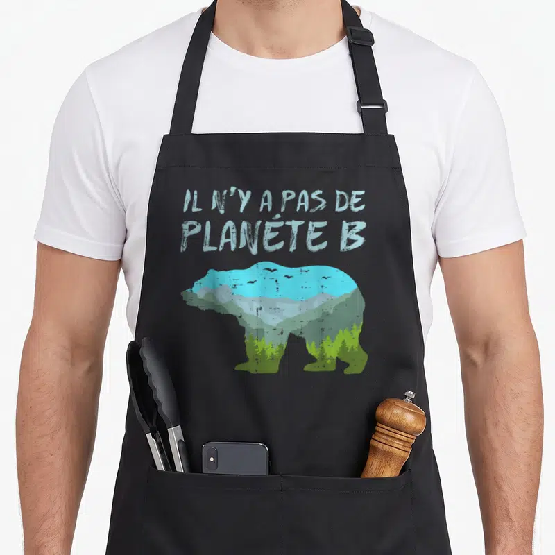 Tablier de cuisine noir avec silhouette d'ours intégrant montagnes forêts et texte « nature environnement »