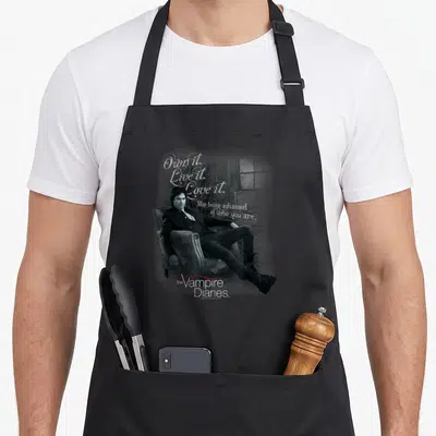 Tablier de cuisine noir avec illustration monochrome d'un homme assis et texteOwn it Live it Love it le vampire diaries