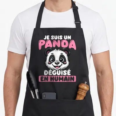 Tablier de cuisine noir avec illustration d'un panda souriant et texte Je suis un panda déguisé en humain en rose et blanc.