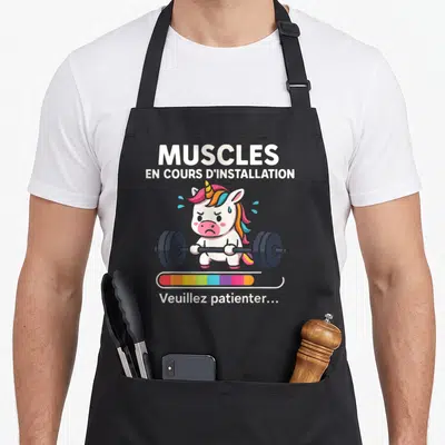 Tablier de cuisine noir illustré d'une licorne rose soulevant un barbel avec une barre de progression colorée sous l'image.