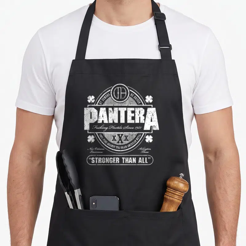Tablier de cuisine noir avec un logo blanc Pantera, des trèfles et le texte Stronger Than All.