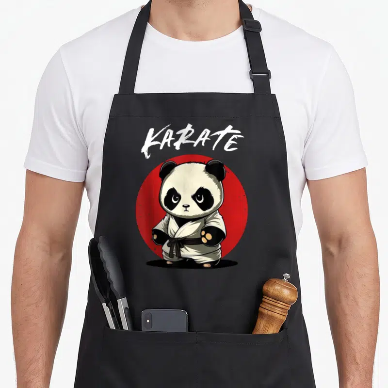 Tablier de cuisine noir avec un panda karatéka en kimono blanc devant un cercle rouge et le mot KARATE en lettres blanches.
