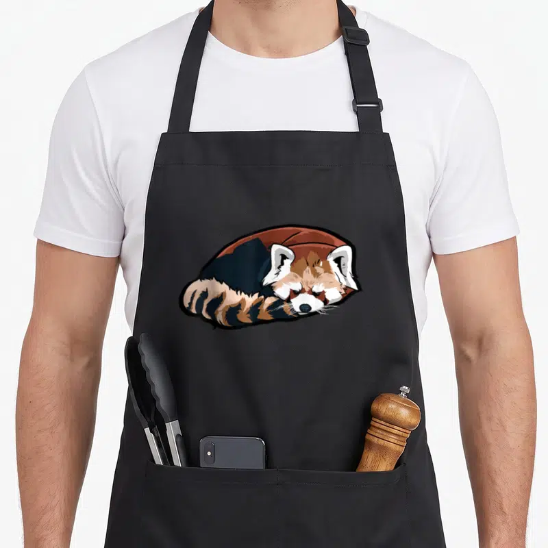 Tablier de cuisine noir avec illustration d'un panda rouge couché en train de dormir paisiblement.