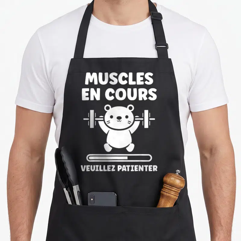 Tablier de cuisine noir avec ours blanc levant une barre et texte Muscles en cours