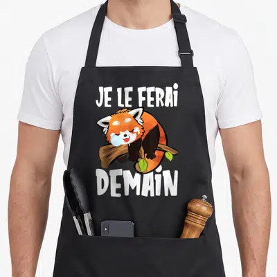 Tablier de cuisine noir avec un renard roux dormant sur une branche et le texte Je le ferai demain en blanc.