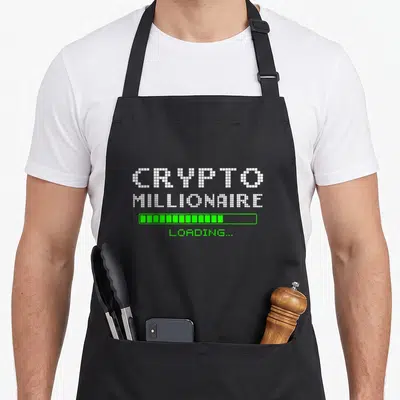 Tablier de cuisine noir avec inscription pixelisée Crypto Millionaire Loading et barre de progression verte.