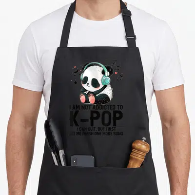 Tablier de cuisine noir avec un panda aux écouteurs turquoise et le texte I AM NOT ADDICTED TO K-POP imprimé en noir.