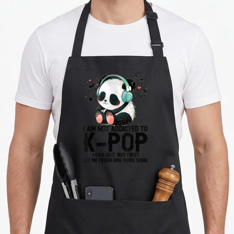 Tablier de cuisine noir avec un panda aux écouteurs turquoise et le texte I AM NOT ADDICTED TO K-POP imprimé en noir.