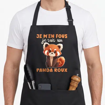 Tablier de cuisine noir avec illustration d'un panda roux souriant et texte orange « Je m'en fous je suis un panda roux ».