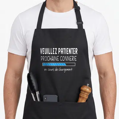Tablier de cuisine noir avec texte blanc Voeuillez patienter prochaine connerie et barre de chargement bleue stylisée au centre.