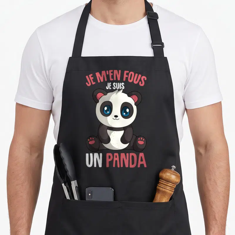 Tablier de cuisine noir avec un panda assis aux yeux bleus et le texte Je m'en fous je suis un panda en rose et blanc.