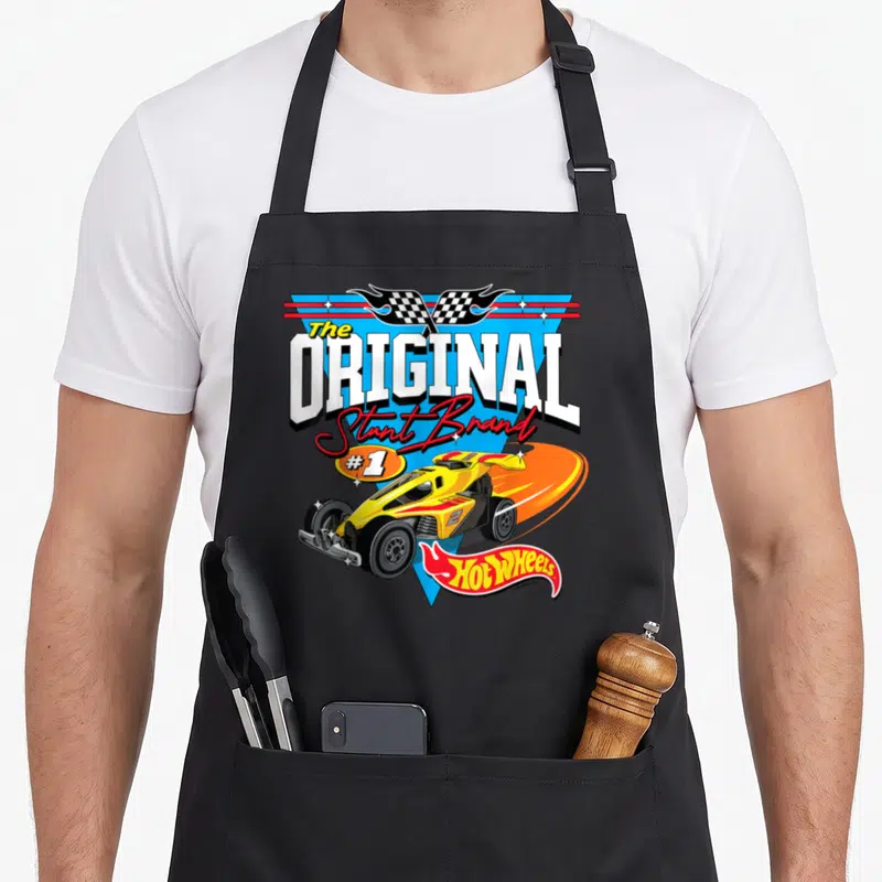 Tablier de cuisine noir avec une illustration de course jaune, flammes orange et drapeau à carreaux au sommet.
