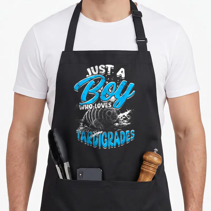 Tablier de cuisine noir avec illustration bleue d'un tardigrade et texte Just a Boy Who Loves Tardigrades en style graffiti.
